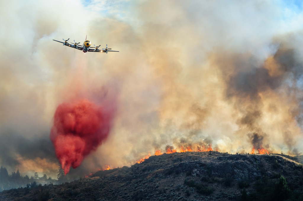 A bomber plane drops red fire retardant on flames that burned Monday evening through the sagebrush near Spotted Lake west of Osoyoos. (Richard McGuire photo)