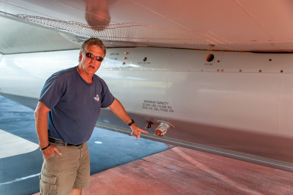 Ben Moerkoert, Air Attack officer, points to where a hose is connected to fill a tank with fire retardant. The tank can hold up to 3,000 U.S. gallons. Sometimes the plane is flown back to base after it drops its load so that more retardant can be added for another drop. (Richard McGuire photo)