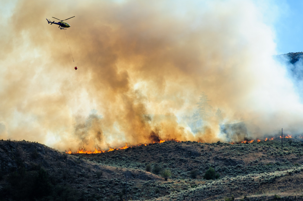 A helicopter prepares to drop water on a fire that burned through sagebrush near Spotted Lake west of Osoyoos on Aug. 19, 2013. (Richard McGuire photo)