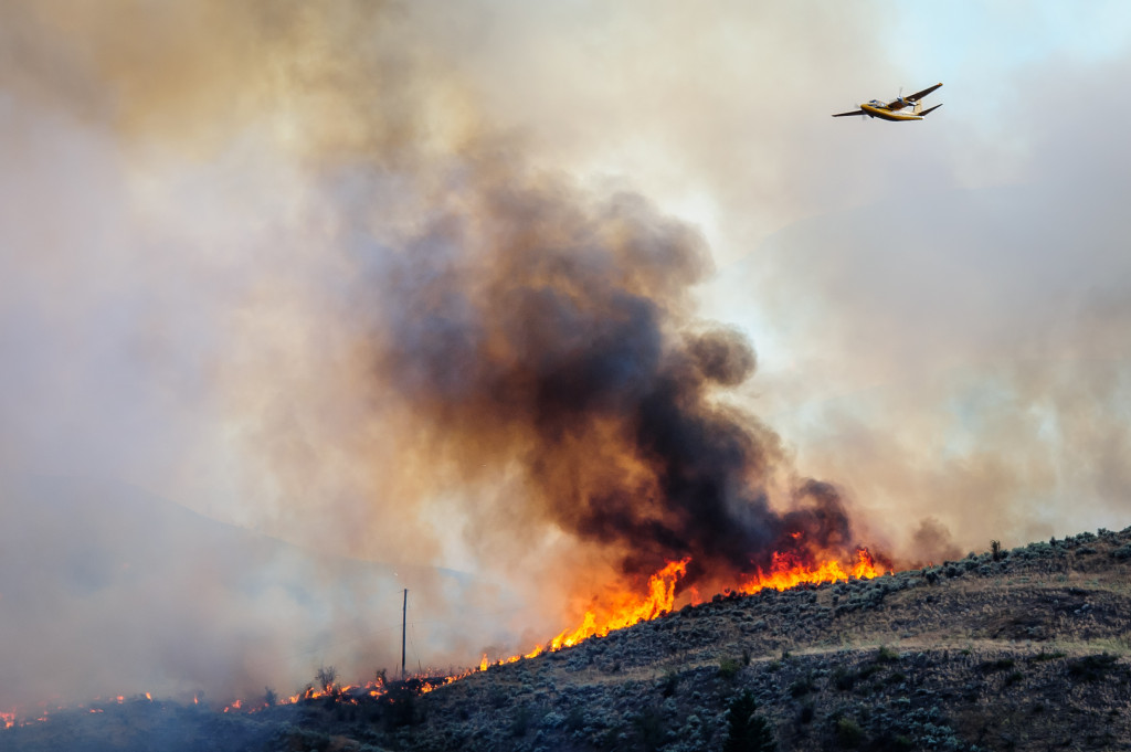 A bird dog plane flies above a fire marking the route for a bomber to follow. The fire was fanned by gusting winds as it spread through sagebrush near Spotted Lake west of Osoyoos on Aug. 19, 2013. The aerial attack on the fire is directed from the bird dog. (Richard McGuire photo)